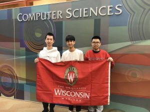 Three team members in front of the Computer Sciences sign.